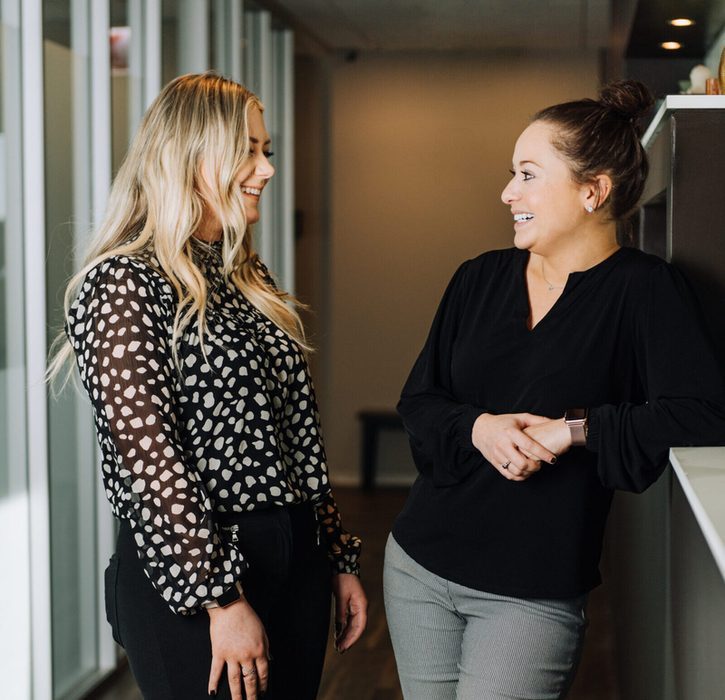 Two fieldwork employees talking in a hallway