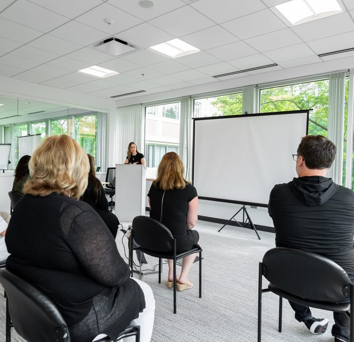 A conference room full of people watching a presentation