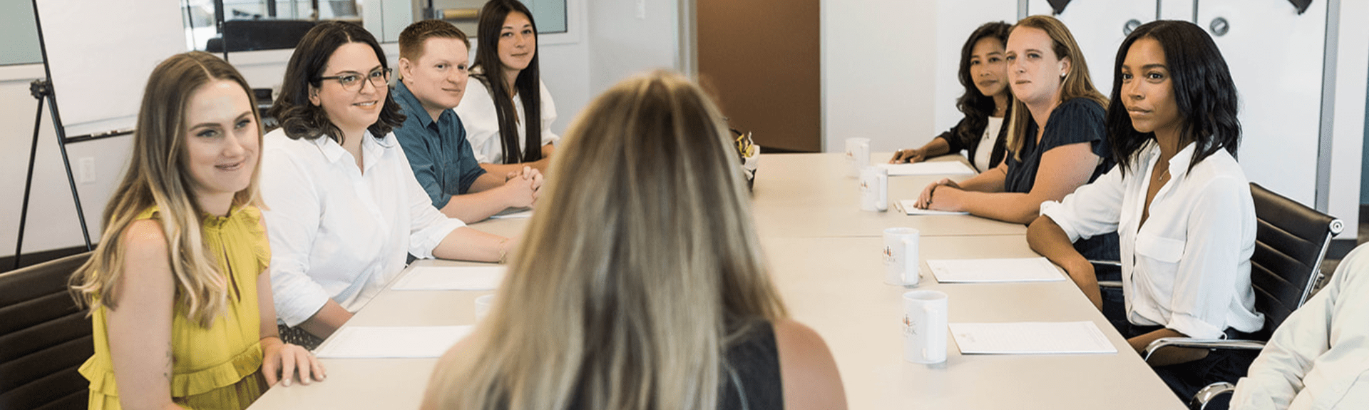 participants sitting in a focus group with a moderator at the head of the table